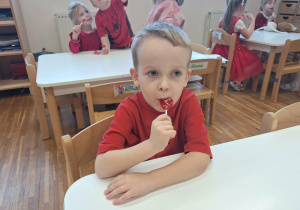 chłopiec liże lizaka