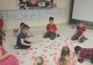 przedszkolaki składają w całość serca z literkami