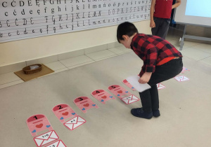 chłopiec dopasowuje kopertę do skrzynki z odpowiednią cyfrą