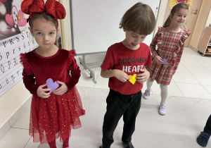 chłopiec z dziewczynką trzymają serduszka