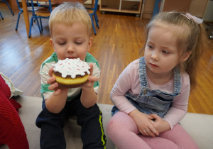 chłopiec trzyma pączka