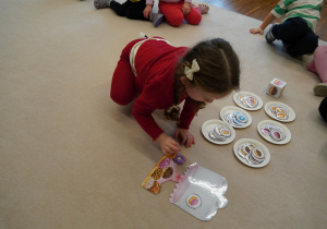 dziewczynka układa obrazki z pączkami