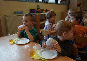 chłopiec gryzie pączka