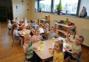 dzieci jedzą pączki