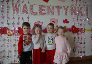 dzieci pozują na ściance i uśmiechają się