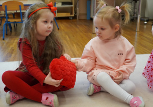 dziewczynka podaje koleżance serduszko