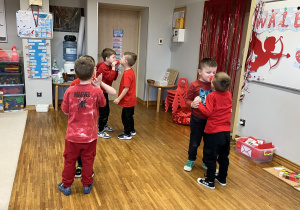 Dzieci trzymają piłkę między nosami