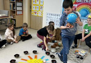 Chłopiec trzyma globus a dziewczynka rozkłada koraliki
