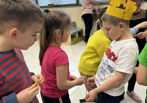 Chłopiec częstuje dzieci cukierkami