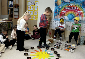 Chłopiec trzyma globus a dziewczynka rozkłada koraliki