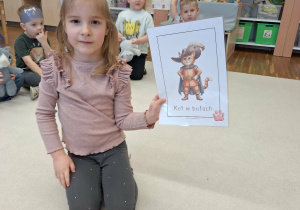 dziewczynka pokazuje ilustracje z bajkowym kotem