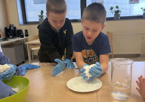 chłopcy wykonują eksperyment ze sztucznym śniegiem