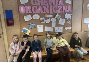 dzieci siedzą przed klasą Chemiczną