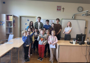 dzieci wraz z Panią i uczniami pozują do wspólnego zdjęcia w sali języka niemieckiego