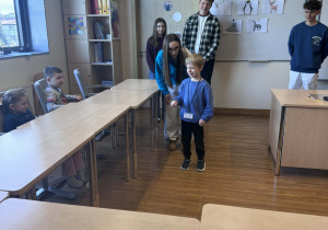 chłopiec pokazuje dzieciom wybrane zwierzę polarne w grze kalambury za nim stoją uczniowie