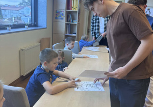 uczniowe rozdają dzieciom kolorowanki ze zwierzętami polarnym