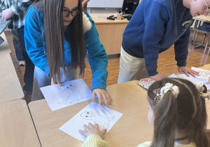 uczniowe rozdają dzieciom kolorowanki ze zwierzętami polarnymi