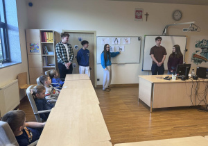 dzieci siedzą w ławkach i uczą sie niemieckich nazw zwierząt polarnych