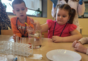 chłopiec i dziewczynka wykonują eksperyment "co pływa a co tonie"?