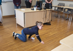 chłopiec pokazuje dzieciom wybrane zwierzę polarne w grze kalambury za nim stoją uczniowie