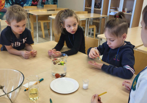 dzieci wykonują eksperyment z papierkami zmieniającymi kolor