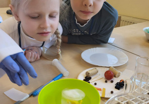 chłopczyk i dziewczynka obserwują eksperyment z topniejącym lodem