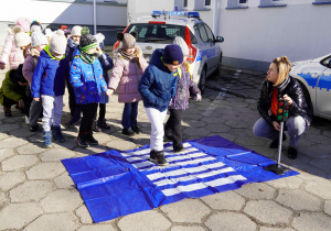 Dzieci przyglądają się sygnalizacji świetlnej i przechodzą przez pasy