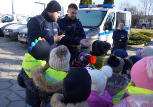 Pan Policjant pokazuje wyposażenie kolegi policjanta