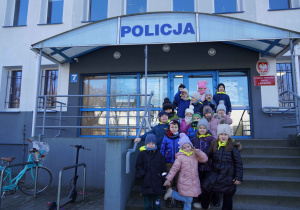 Grupowe zdjęcie sześciolatków na tle budynku KPP w Bełchatowie