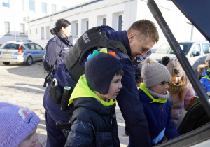 Pan Policjant pokazuje dzieciom wyposażenie samochodu