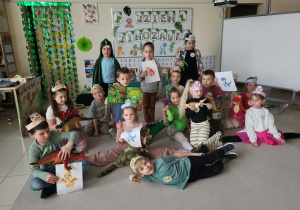 grupowe zdjęcie dzieci z dinozaurowymi zabawkami i książkami