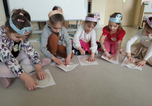 dzieci otwierają papierowe jaja dinozaurów