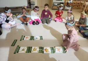 dziewczynka w odpowiednim miejscu kładzie obrazek dinozaura roslinożernego