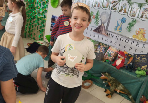 chłopiec pokazuje znaleziony obrazek z dinozaurem