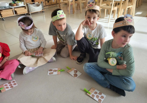 dzieci siedzą na dywanie podczas zabawy matematycznej z liczeniem