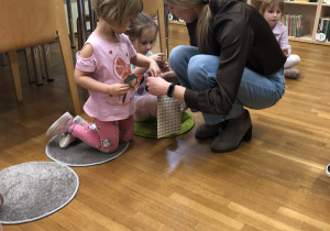 pani rozdaje dzieciom naklejki