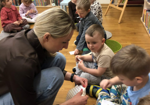 pani rozdaje dzieciom naklejki