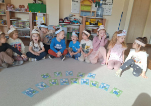 dzieci siedza na dywanie