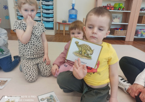 chłopiec pokazuje dinozaura na obrazku