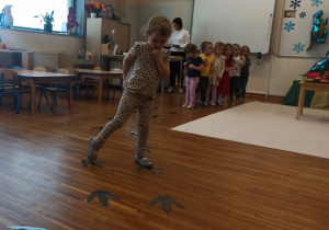 dziewczynka idzie po śladach dinozaura