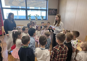 dzieci stoój wokół uczenicy słuchając poleceń