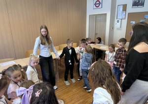 dziecie stoją w kole, trzymając sie za ręce z uczenicami