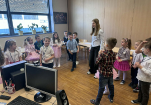 dzieci stoją w kole z uczenicą i się uśmiechają