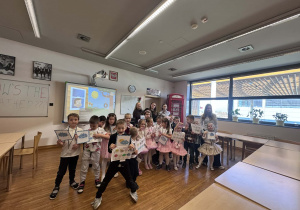 dzieci trzymaja obrazki i pozuja z Paniami i uczenicami do wspólnego zdjęcia