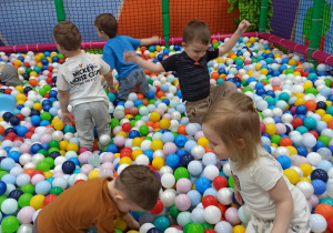 dzieci bawią się w basenie z kolorywymi kulkami