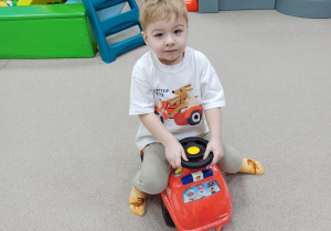 chłopiec jedzie samochodzikiem