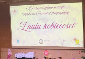 dzieci stoja na scenie ubrane w żółte koszulki i śpiewają utwór "five little ducks"