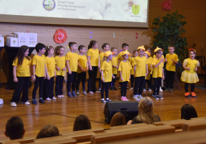 ubrane w żółte koszulki i śpiewają utwór "five little ducks"