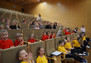 dzieci oraz rodzice siedzą na widowni