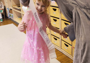 Pani zakłada szarfę miss